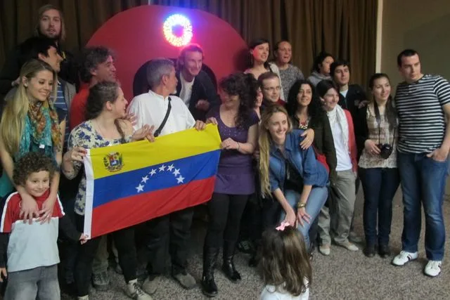 Integrantes e invitados del festival de 2011 posan con una bandera de Venezuela